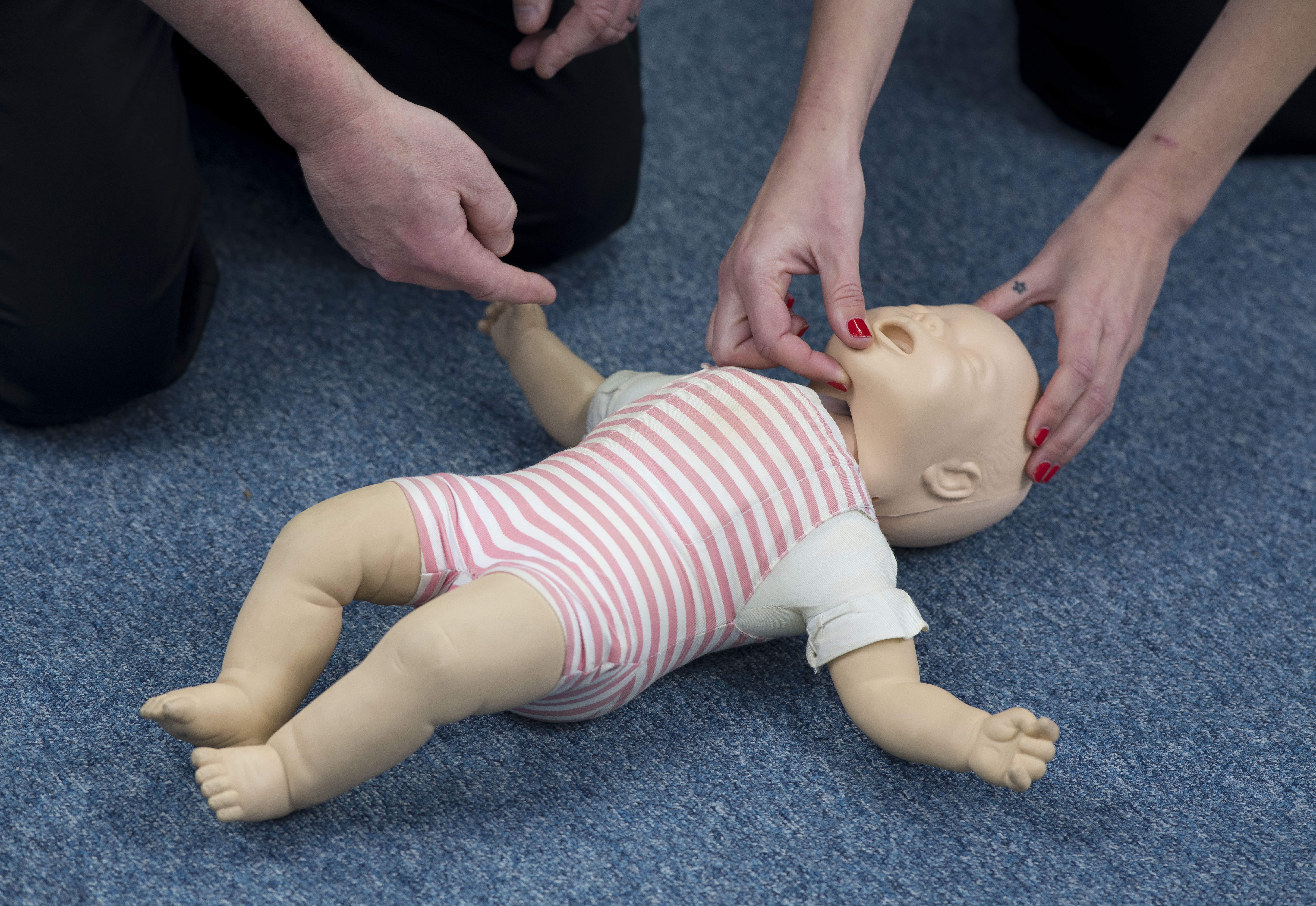 practicing cpr on a baby as part of paediatric first aid